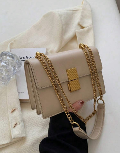 Bolso con solapa acolchada y con cadena de metal
